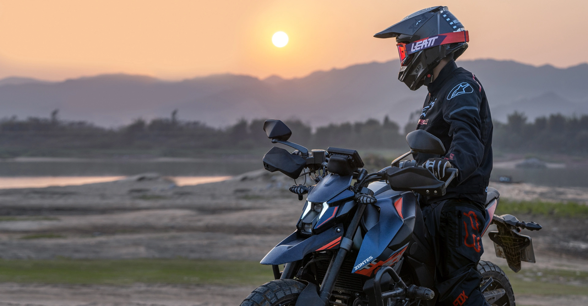 Zontes Motos San Isidro - motociclista conduciendo Zontes 200G en paisaje abierto al atardecer
